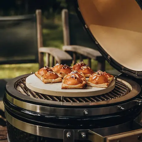 Backwaren auf einem Pizzastein im Grill