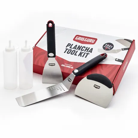 Set mit Grillwerkzeugen, darunter Spatel und Schaber, auf einer Verpackung mit der Aufschrift 'Plancha Tool Kit'