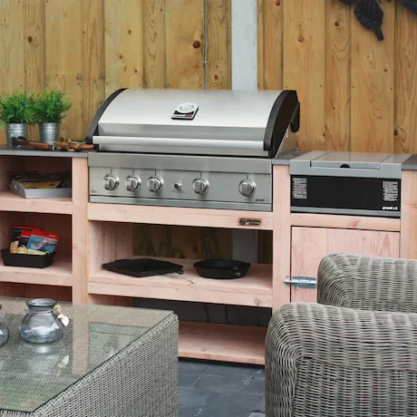 Den Grandhall Elite G4 Einbau-Gasgrill in einem Garten mit Holzoptik