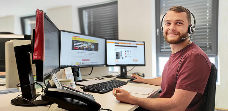 Mann mit Headset arbeitet an einem Computer